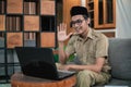 man in civilian uniform use laptop while sitting with hand gestures to say hello