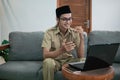 man in civilian uniform use laptop and smartphone while sitting with hand gestures to explain