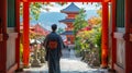 A man clad in traditional Japanese robes stands at the entrance of a pagoda head bowed in deep contemplation as Royalty Free Stock Photo