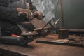 Man clamps iron products into c-clamps. Man works with clamps. Steel workshop concept