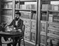 Man in classic suit sits in vintage interior, library Royalty Free Stock Photo