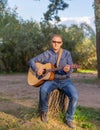 A man with a classical or Spanish guitar in a hat in nature Royalty Free Stock Photo