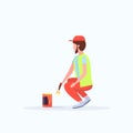 Man cleaner in uniform using paintbrush and paint bucket male janitor painting street sidewalk decoration road service