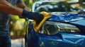 Man cleaning a blue car.AI generated image Royalty Free Stock Photo