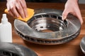 Man cleaning a brake rotor from rust, using a fabric cloth and anti rust spray Royalty Free Stock Photo