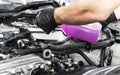 A man cleaning car engine with shampoo and brush. Car detailing or valeting concept. Selective focus. Car detailing. Cleaning with Royalty Free Stock Photo