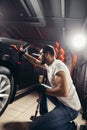 Man cleaning car with microfiber cloth, car detailing or valeting concept