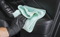 A man cleaning car seat with blue microfiber cloth. Car detailing or valeting concept. Selective focus. Car detailing. Cleaning wi Royalty Free Stock Photo