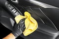 A man cleaning car seat with yellow microfiber cloth. Car detailing or valeting concept. Selective focus. Car detailing. Cleaning