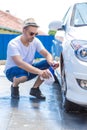 Man cleaning car wheel with cloth and spray bottle Royalty Free Stock Photo