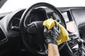 A man cleaning car with yellow microfiber cloth. Car detailing or valeting concept. Selective focus. Car detailing. Cleaning with