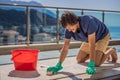 Man cleaning the carpet with foam on the balcony Royalty Free Stock Photo