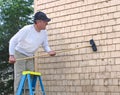Man cleaning cedar shingles Royalty Free Stock Photo