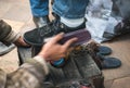 man cleaning customer shoes on city pavement. Royalty Free Stock Photo