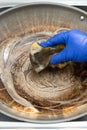 man cleaning a dirty cooking pan vertical composition