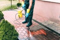 Man cleaning dirty red concrete pavement block Royalty Free Stock Photo