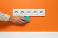 Man cleaning five-socket wall outlet Royalty Free Stock Photo