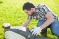 Man cleaning or fixing lawn mower blade Royalty Free Stock Photo