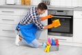 Man cleaning kitchen oven with rag Royalty Free Stock Photo