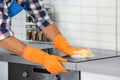 Man cleaning kitchen stove with sponge Royalty Free Stock Photo