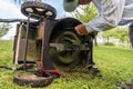 Man cleaning lawn mower blade. Royalty Free Stock Photo