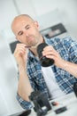 man cleaning lens digital camera with special brush Royalty Free Stock Photo