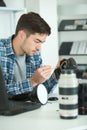 Man cleaning lens digital camera with special brush Royalty Free Stock Photo