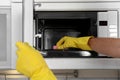 Man cleaning microwave oven in kitchen Royalty Free Stock Photo