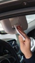 Man cleaning mirror with wet wipe in car, closeup. Protective measures Royalty Free Stock Photo
