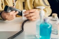 Man Cleaning a mouthpiece of the telephone handset with alcohol pad.Hygiene concept. prevent the spread of germs and bacteria and