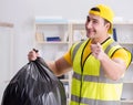Man cleaning the office and holding garbage bag Royalty Free Stock Photo