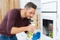 Man cleaning oven in kitchen Royalty Free Stock Photo