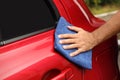 Man cleaning red auto with duster, closeup Royalty Free Stock Photo