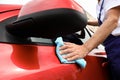 Man cleaning red auto with duster, closeup. Royalty Free Stock Photo