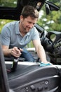 man cleaning salon with rag in car