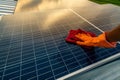 Man cleaning solar panel on roof. Solar panel or photovoltaic module maintenance. Sustainable resource and renewable energy for go Royalty Free Stock Photo