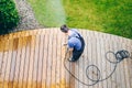 Man cleaning terrace with a power washer - high water pressure c