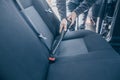 Man cleaning, vacuuming interior of the car by vacuum cleaner, transport concept Royalty Free Stock Photo