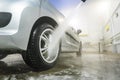 Man cleaning vehicle with high pressure water spray or jet. Car wash details. washing the rear wheel of a car Royalty Free Stock Photo