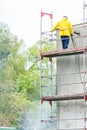 Man cleaning wall. Scaffolding Royalty Free Stock Photo