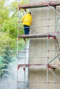 Man cleaning wall. Scaffolding Royalty Free Stock Photo