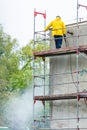 Man cleaning wall. Scaffolding Royalty Free Stock Photo