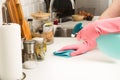 Man cleaning a white kitchen countertop with a sponge cloth