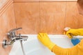 Man cleans bathroom with sponge and cleaning products from the mold Royalty Free Stock Photo