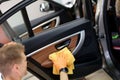 Man cleans car door handle with cloth and car detailing Royalty Free Stock Photo