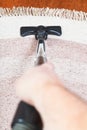 Man cleans carpet with vacuum cleaner Royalty Free Stock Photo