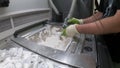 Man cleans details printed on industrial 3D printer from white plastic powder