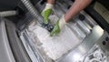 Man cleans details printed on industrial 3D printer from white plastic powder