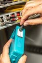 A man cleans the fiber optic cable connectors with a special blue cleaner. Cleaning connectors close up against the Royalty Free Stock Photo