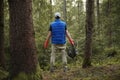 Man cleans garbage and plastic bottle in forest. Green volunteering. Caring for environment